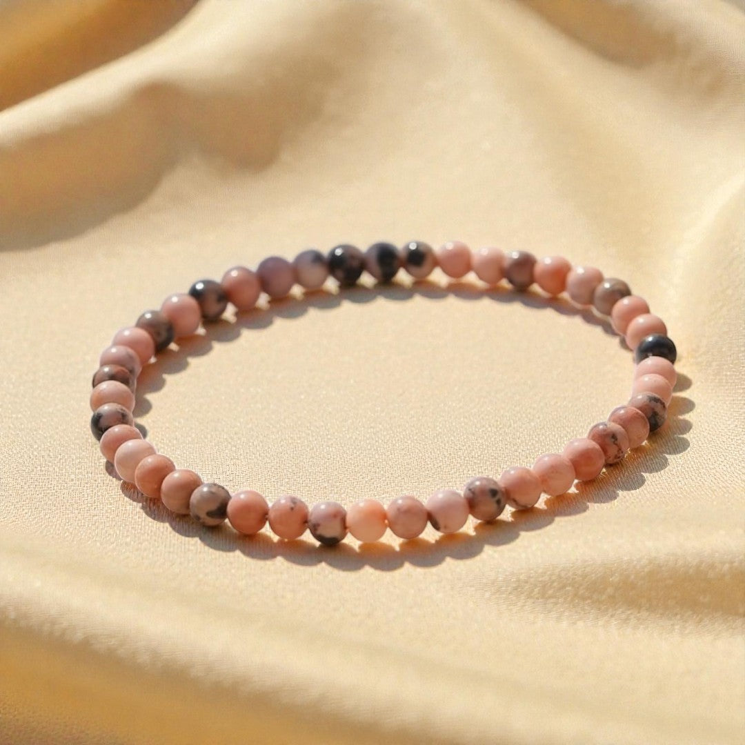 Atelier Tibet delicate pink rhodonite beaded bracelet with black accents, 4mm natural stones on elastic cord.