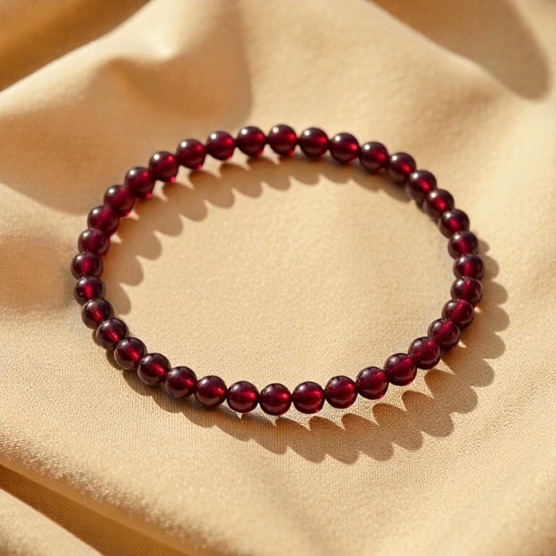 Atelier Tibet fine bracelet with 4mm deep red garnet beads on elastic cord.