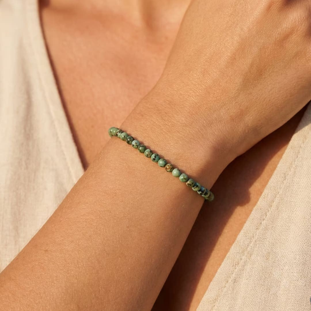 Atelier Tibet delicate bracelet with 4mm African Turquoise natural stones on a woman's wrist.